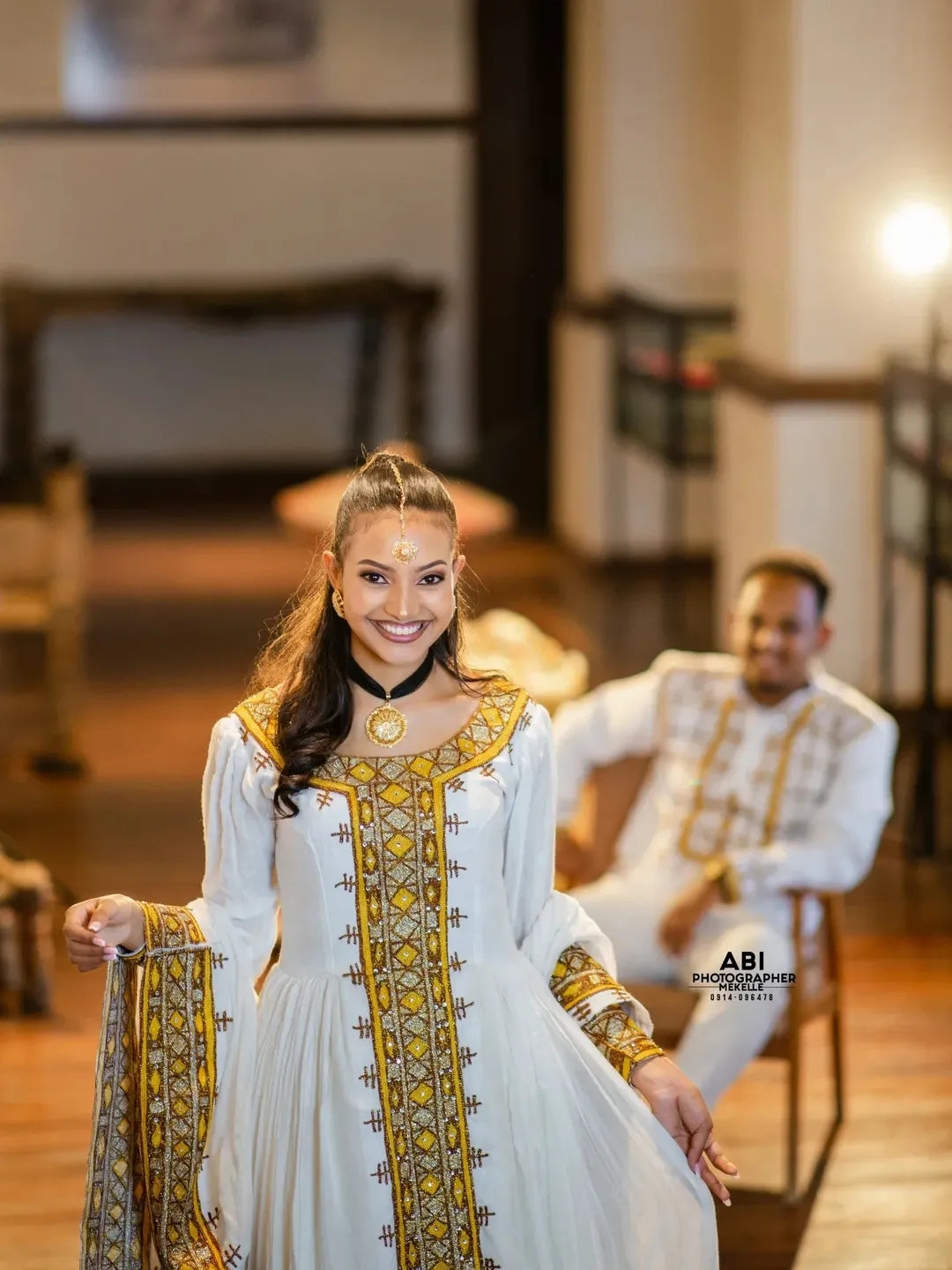 Woman in a white and gold traditional gold Habesha Libs with a blurred background
