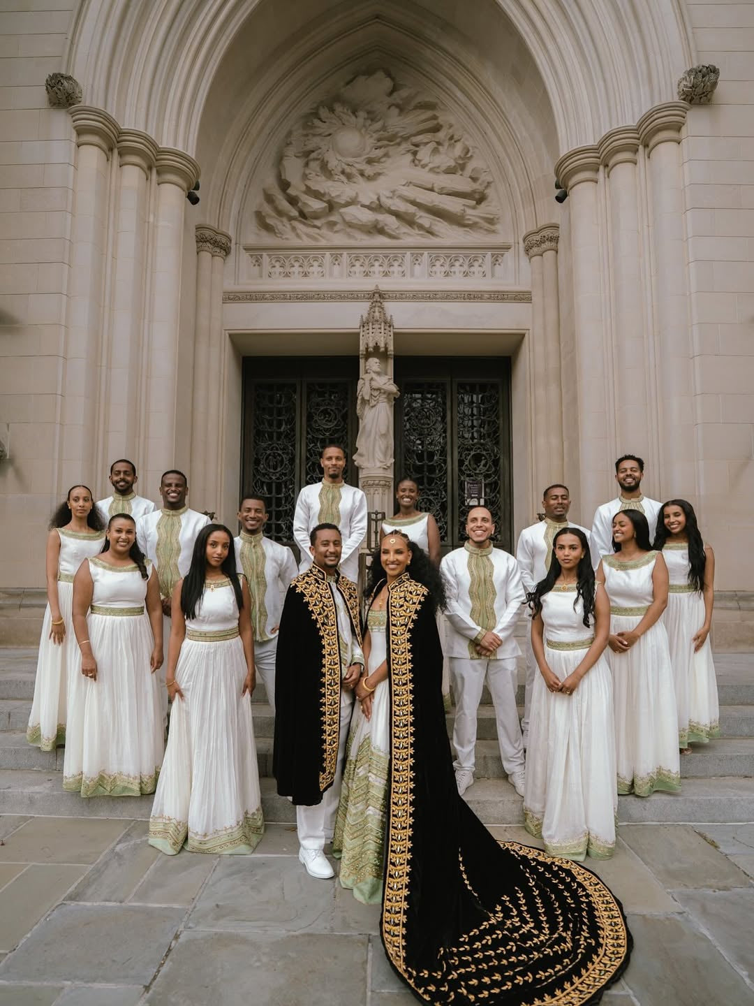 Group of people in formal Habesha Outfit couple Set standing in front of a large building with architectural details.