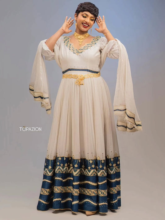 Woman wearing a Habesha Couple Matching Set with a blue and white pattern, posing against a gray background.