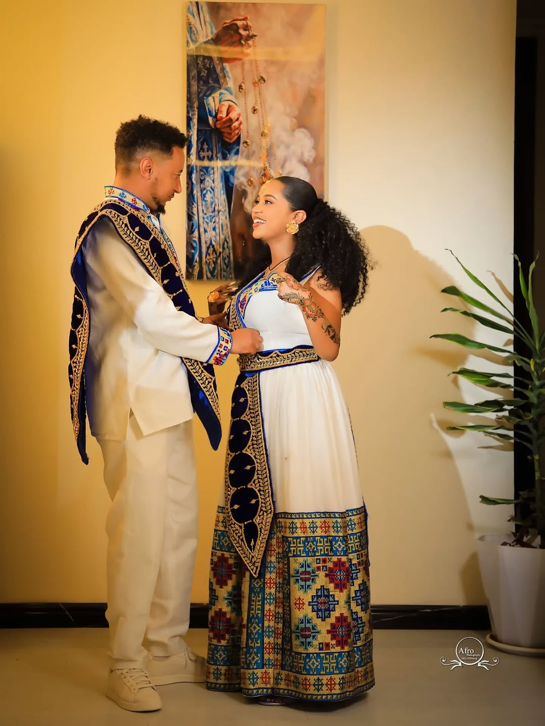 Couple in traditional Ethiopian Matching Couple Set standing close together indoors.