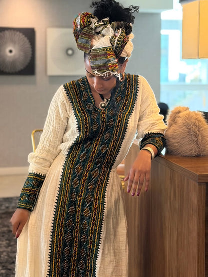 Person wearing a traditional outfit with intricate patterns in an indoor setting.