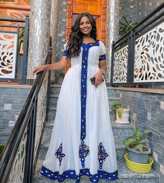 Woman in a white and blue dress standing on a staircase with decorative railings.