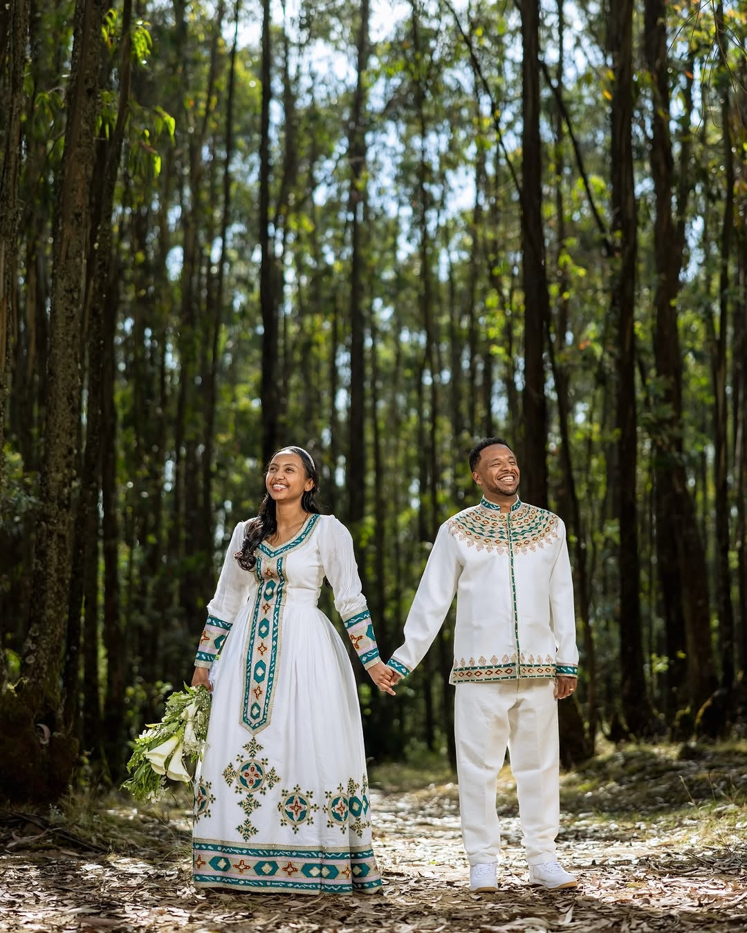 Couple in traditional Green Habesha Wedding Couple Outfit standing in a forest