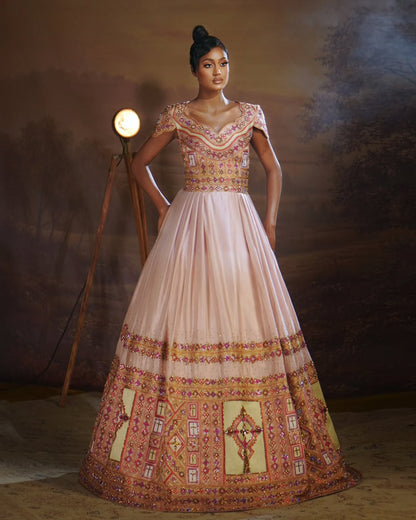 Woman wearing a traditional embroidered Habesha Outfit couple Set  in a studio setting with a warm light.