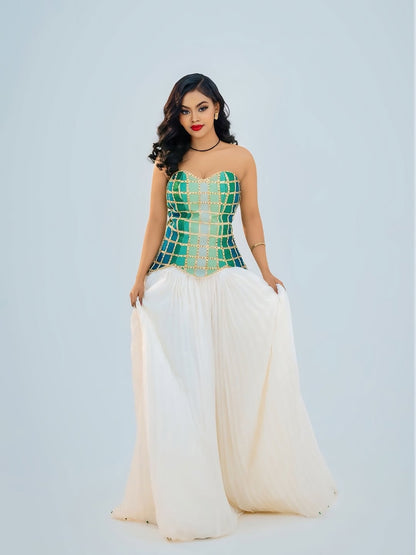 Woman wearing a green and white Ethiopian cultural dress with a geometric pattern on a light gray background