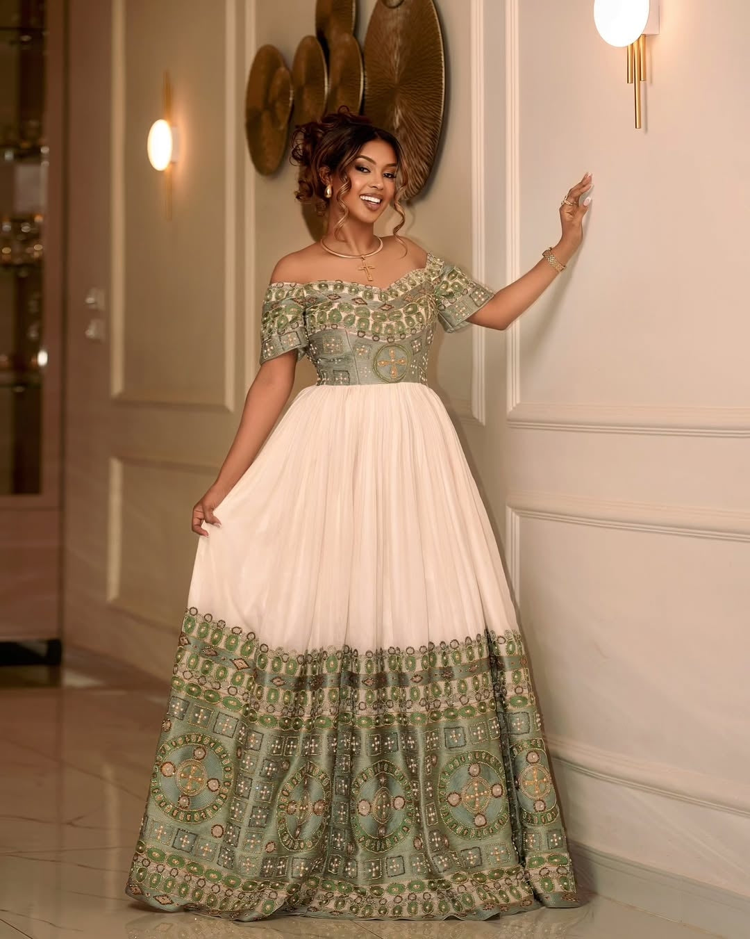 Woman wearing a green and white patterned Green Ethiopian Wedding Dress in an elegant interior setting.