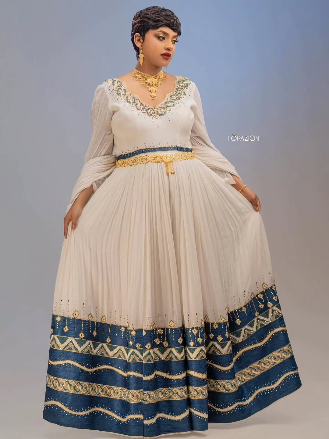 Woman wearing a Habesha Couple Matching Set with white and blue design, standing against a gradient background.