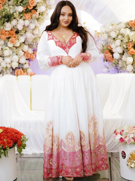 Woman in a white and pink traditional red Habesha Kemis with floral decorations in the background