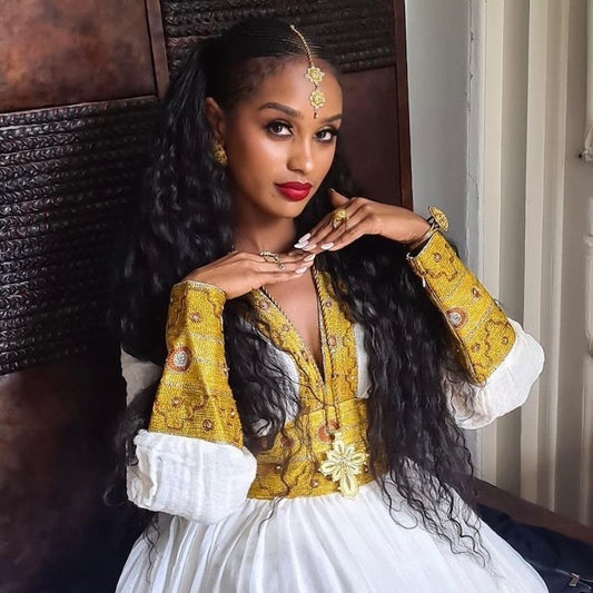 Yellow Habesha dress with multicolor tibeb embroidery for engagement ceremonies
