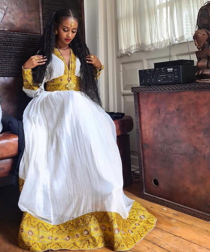 Yellow Habesha dress with multicolor tibeb embroidery for engagement ceremonies