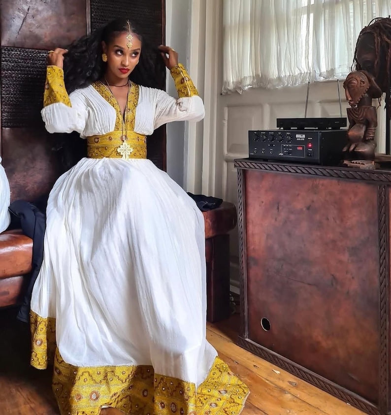 Yellow Habesha dress with multicolor tibeb embroidery for engagement ceremonies