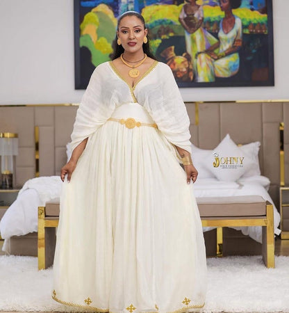 Gold Habesha dress in handwoven cotton featuring silver tilf embroidery for engagement ceremonies