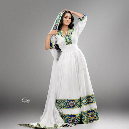 Woman wearing a traditional outfit with green ethiopian cultural dress on a gray background