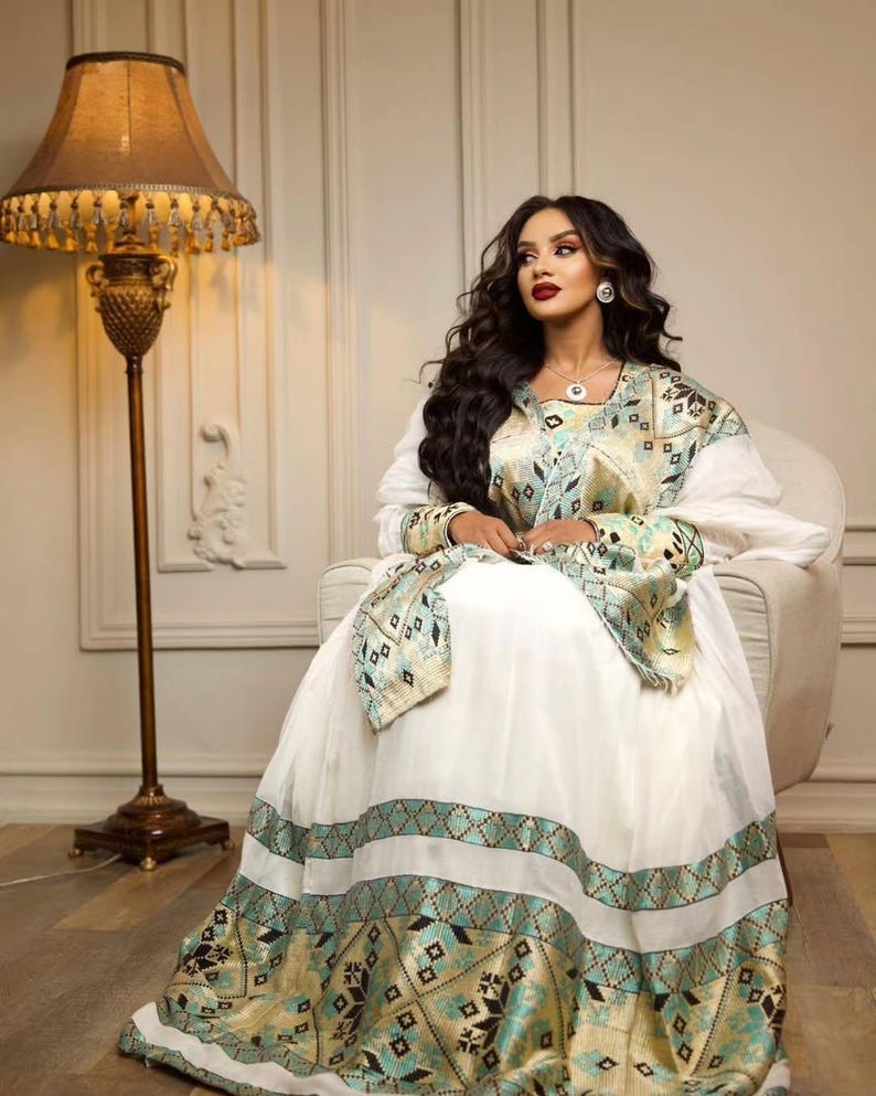 Green Habesha kemis in soft dress featuring gold tibeb embroidery for holiday ceremony