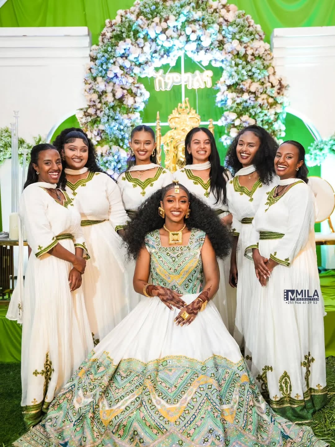 Group of women in traditional Green Habesha Wedding Dress with a decorated arch in the background