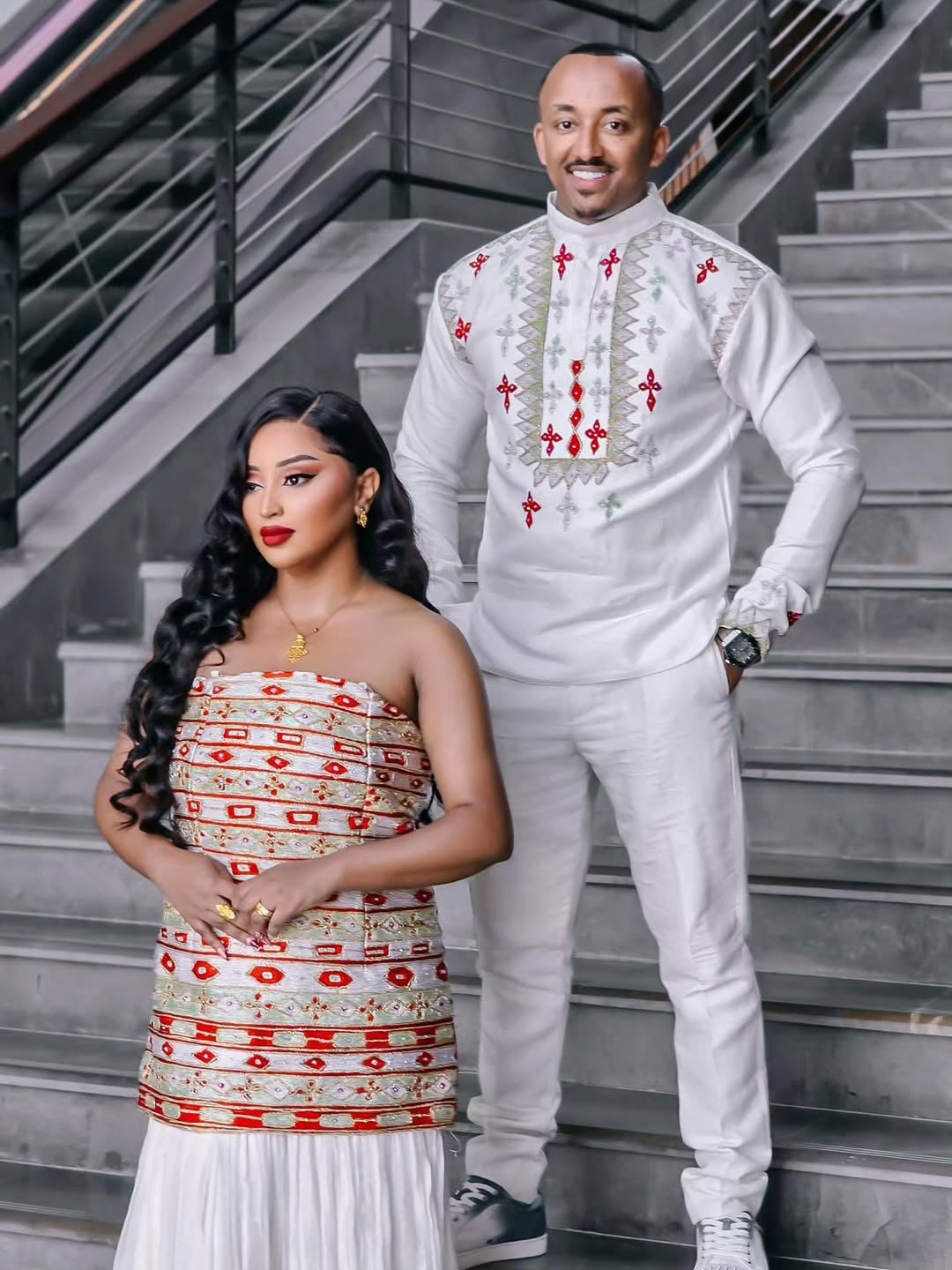 Man and woman in Habesha Couple Matching Set posing together on a staircase in formal attire.