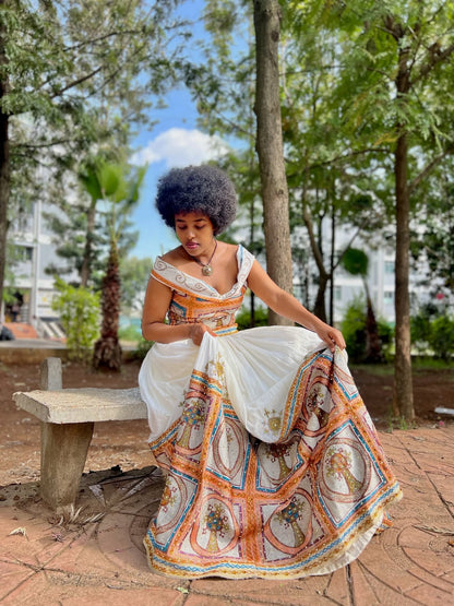 Woman in a colorful dress sitting on a bench in a park