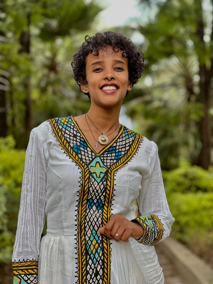 Green Habesha zuria in soft chiffon featuring multicolor tibeb embroidery for Eid celebrations