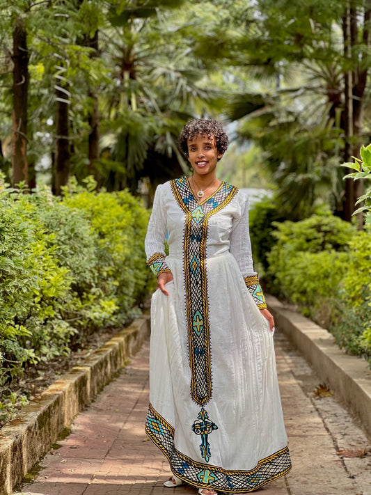 Green Habesha zuria in soft chiffon featuring multicolor tibeb embroidery for Eid celebrations