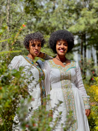 Green Habesha zuria in soft chiffon featuring multicolor tibeb embroidery for Eid celebrations