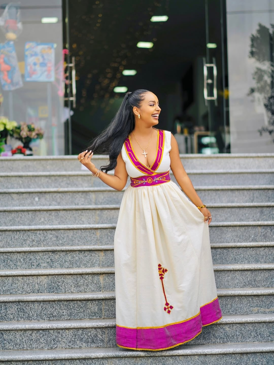 Woman in a Purple Accent Habesha Zuria standing on steps outdoors