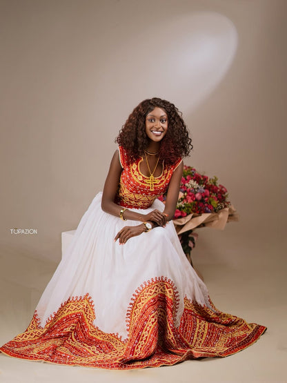 Woman in a traditional Ethiopian cultural dress  with floral arrangement on a beige background