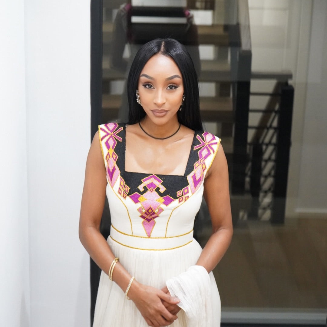 Woman wearing a Ethiopian dress with colorful patterns indoors