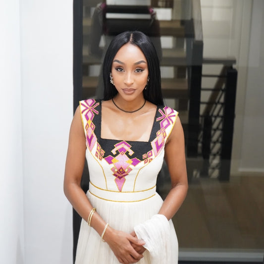Woman wearing a Ethiopian dress with colorful patterns indoors