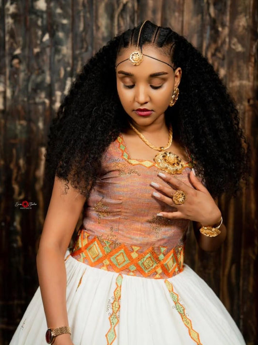 Woman in traditional habesha kemis with intricate jewelry against a dark backgroun