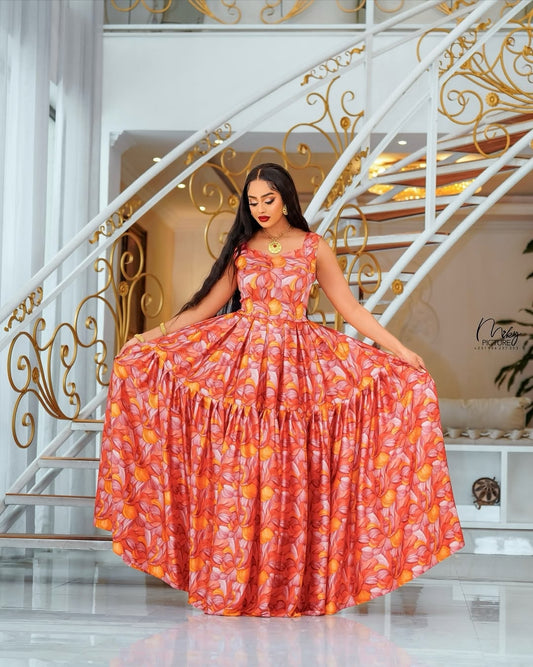Woman in a red floral Habesha Chiffon Dress standing in a luxurious interior setting with gold accents.