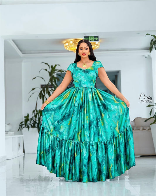 Woman wearing a green dress with a pattern in an indoor setting