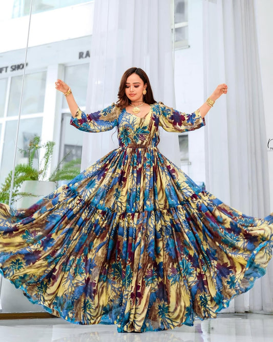 Woman in a colorful floral Ethiopian Kemis  dancing in a bright room with white curtains.