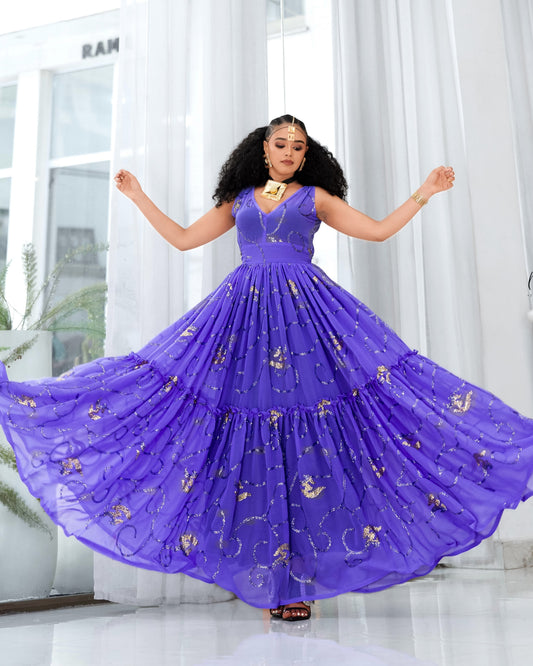 A woman wearing a voluminous purple sleeveless Habesha Dress with gold embroidered motifs, captured mid-spin as the skirt flares out in a bright indoor setting with white curtains.