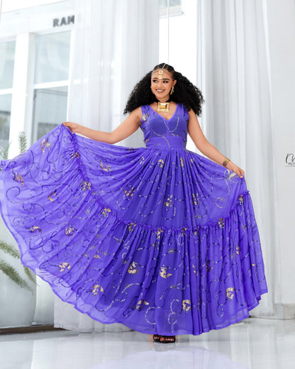 A woman modeling a voluminous purple tiered Habesha Dress with gold floral embroidery, holding out the wide skirt in a bright indoor setting.