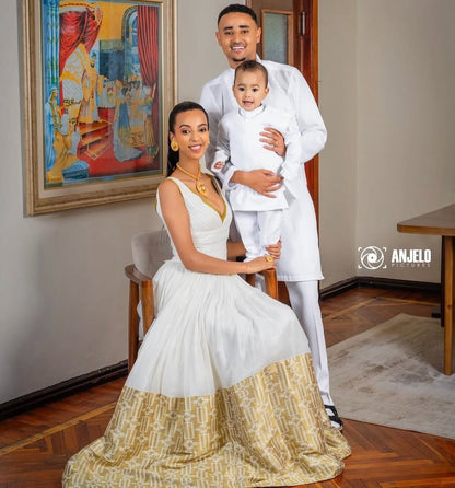Family of three in formal habesha dress  posing indoors with a painting in the background