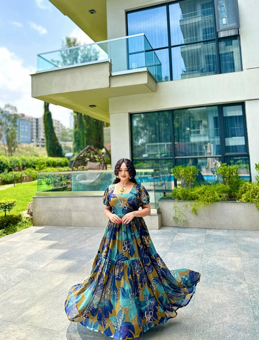 Woman in a blue and gold habesha chiffion standing in front of a modern building with glass windows.